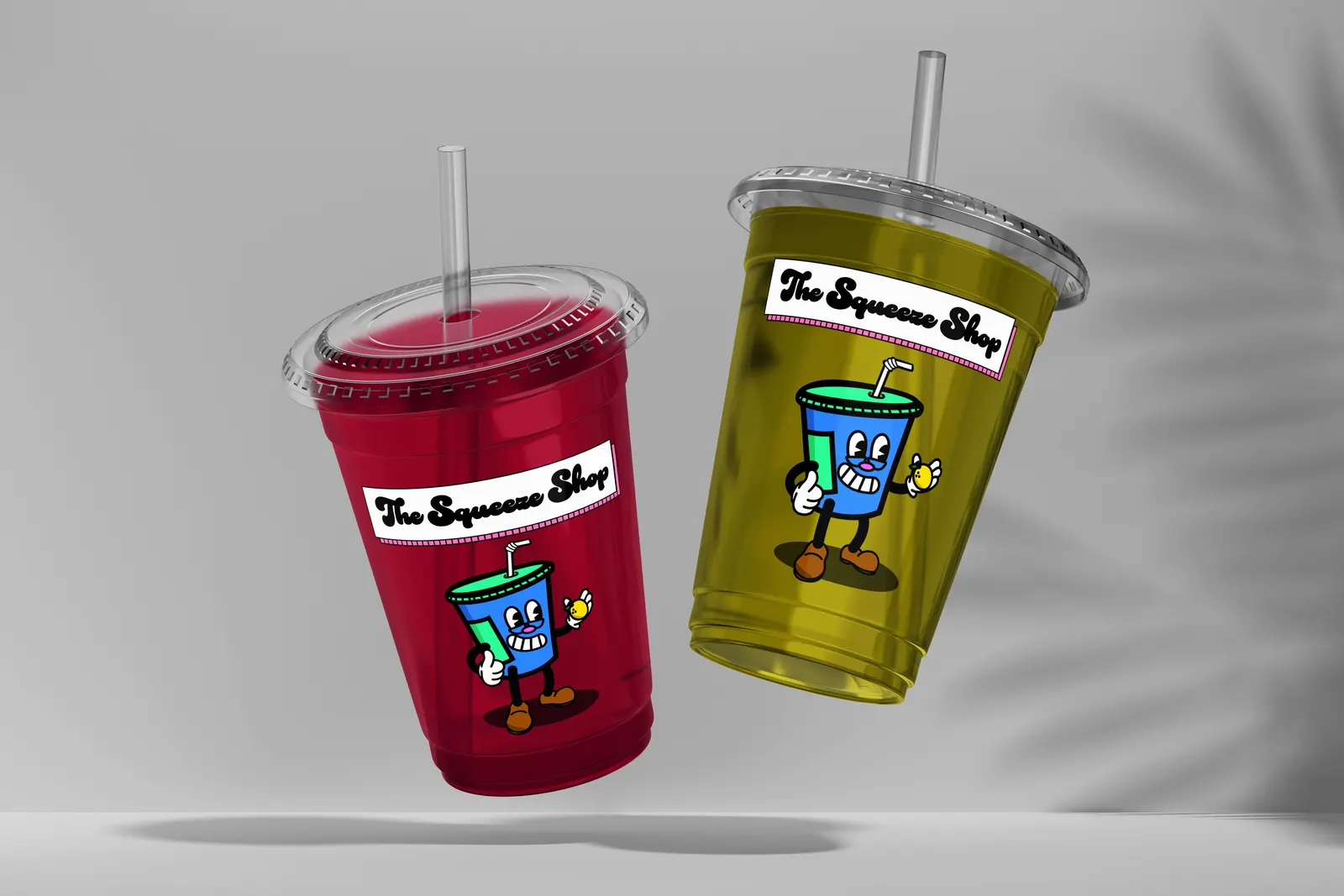 Two clear plastic cups, one red and one yellow, each with The Squeeze Shop logo and mascot